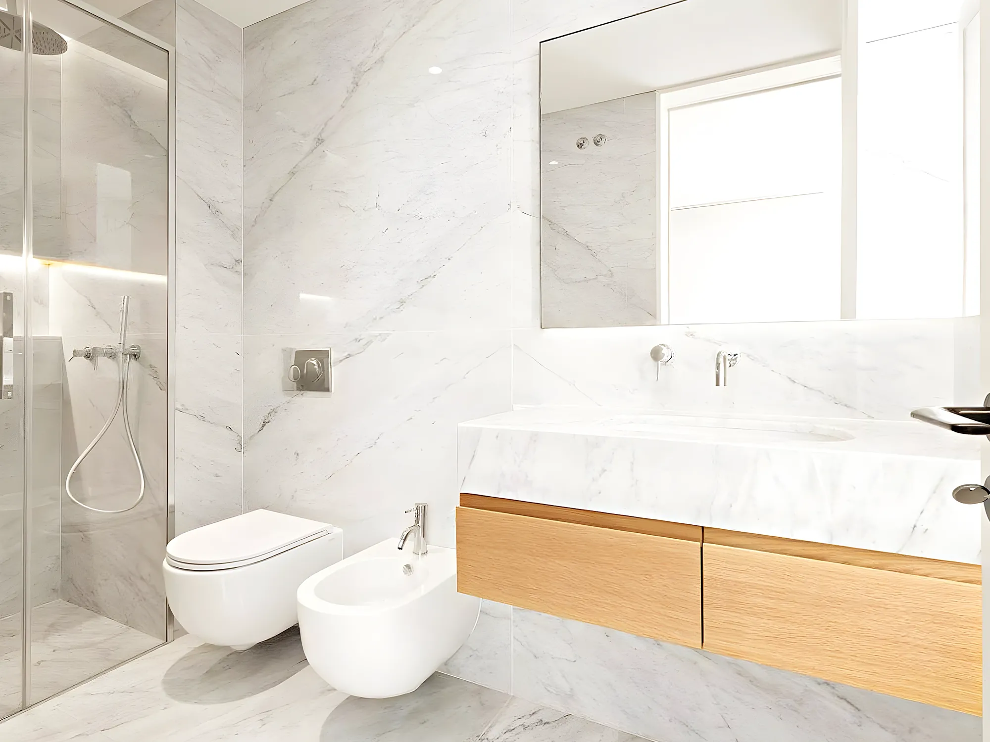 Baño de mármol con mueble de madera y luz natural — reforma de baño en Fuengirola