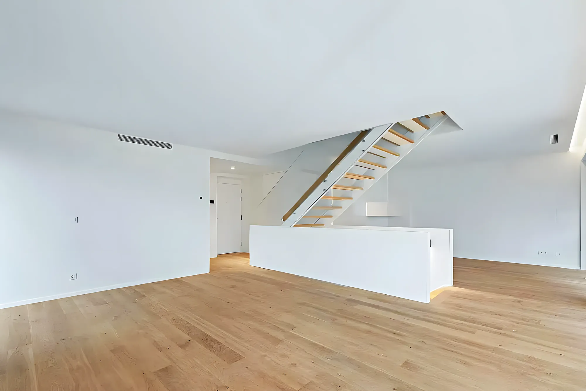 Salón abierto con escalera tras una reforma integral en Fuengirola